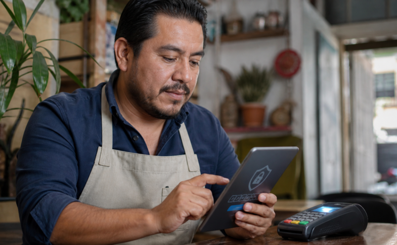 Comerciante activa doble factor de seguridad en una tableta junto a una terminal de pago