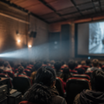 Sala comunitaria de cine en Ciudad de México con proyector encendido y público desenfocado.