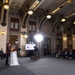La presidenta Claudia Sheinbaum encabeza un acto público ante funcionarios, medios de comunicación y asistentes en un recinto de Palacio Nacional.