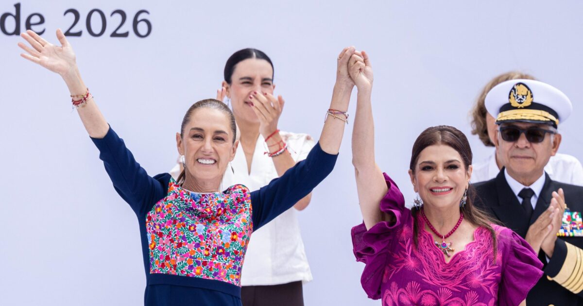 Claudia Sheinbaum y Clara Brugada sonríen con las manos unidas y los brazos levantados durante el acto en el Zócalo.