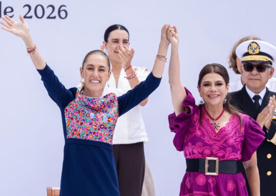 Claudia Sheinbaum y Clara Brugada sonríen con las manos unidas y los brazos levantados durante el acto en el Zócalo.