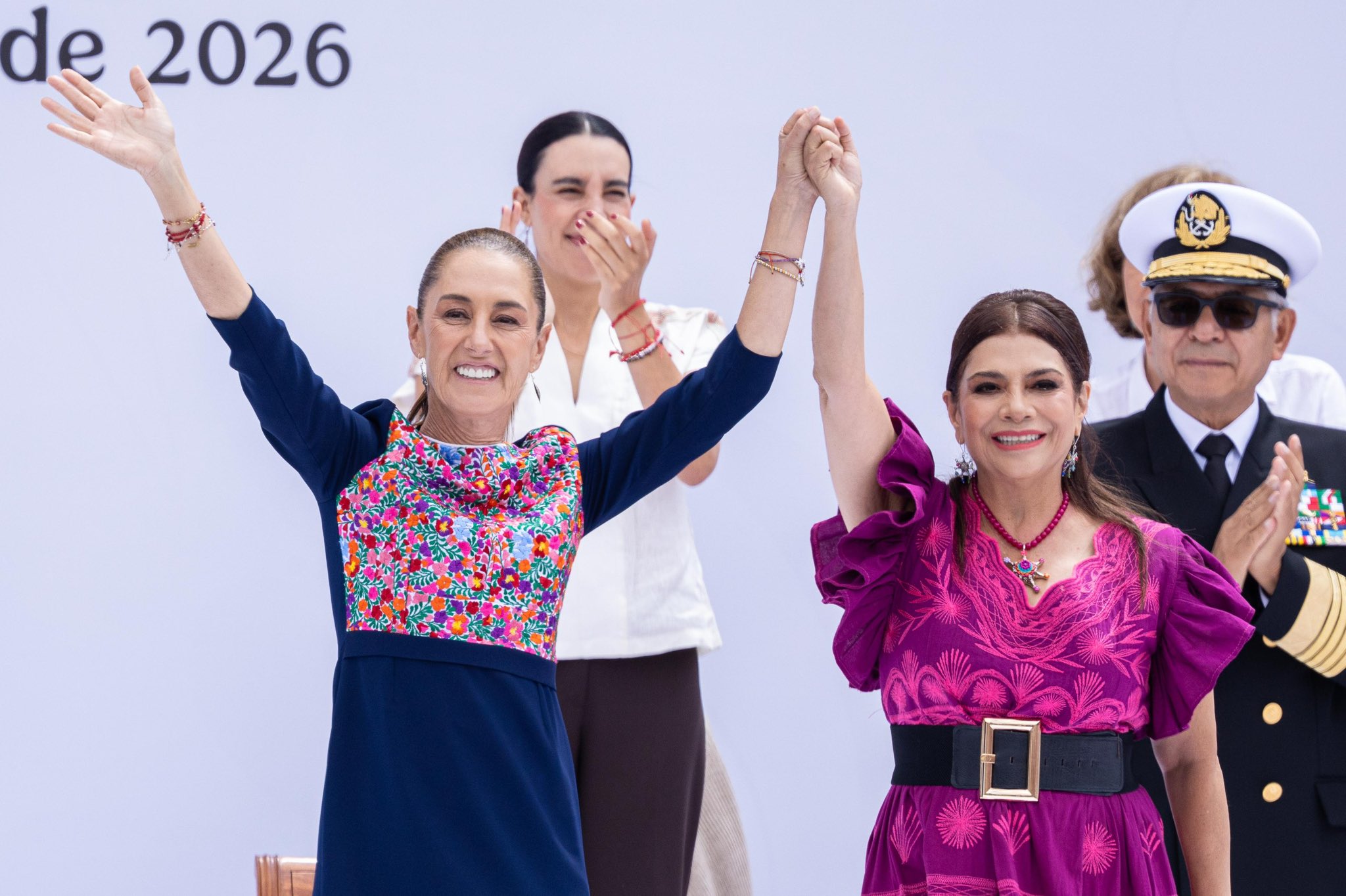 Claudia Sheinbaum y Clara Brugada sonríen con las manos unidas y los brazos levantados durante el acto en el Zócalo.